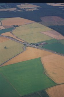 Oblique aerial view of linear crop mark, Charlesfield towards Upper Cairnie farm, from ESE.  Also parts of Upper Cairnie East enclosure in foreground (aircraft at c.NO 043 191).