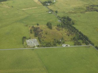 Oblique aerial view centred on the remains of the Roman temporary camp with the cottage and tollhouse adjacent, taken from the SW.