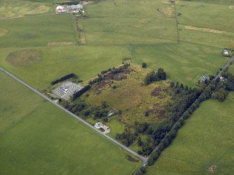 Oblique aerial view centred on the remains of the Roman temporary camp with the cottage and tollhouse adjacent, taken from the S.
