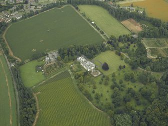 Oblique aerial view centred on the country house, castle, stables and lodge, taken from the SW.