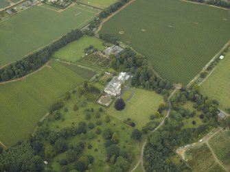 Oblique aerial view centred on the country house, castle, stables and lodge, taken from the S.