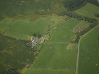 Oblique aerial view centred on the remains of the stone circle and the farmhouse and farmsteading, taken from the W.