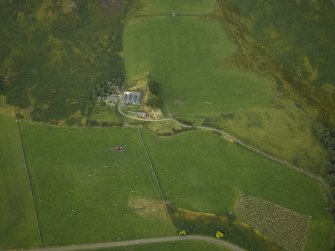 Oblique aerial view centred on the remains of the stone circle and the farmhouse and farmsteading, taken from the SSW.