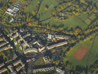 Oblique aerial view centred on the infirmary with the park and winter gardens adjacent, taken from the SE.