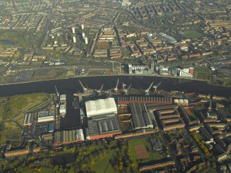 General oblique aerial view centred on the shipyard with the flat and quay adjacent, taken from the SSE.