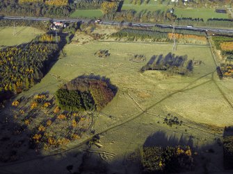 Oblique aerial view centred on the remains of the practice trenches with the farmhouse, farmsteading and cottages adjacent, taken from the SSE.