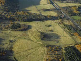 Oblique aerial view centred on the remains of the practice trenches with the farmhouse, farmsteading and cottages adjacent, taken from the ESE.