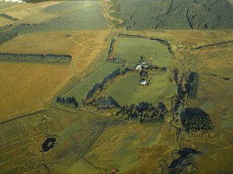 Oblique aerial view centred on the farmhouse and remains of the rig, taken from the SW.