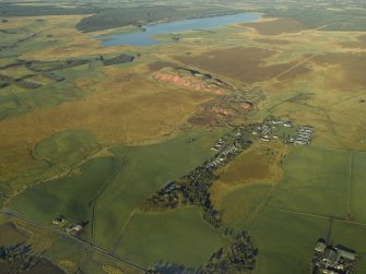 General oblique aerial view centred on the shale-oil works, remains of the shale bings, shale-oil mines, village and remains of the rig, taken from the SE.