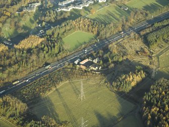 Oblique aerial view centred on the farmhouse, farmsteading and cottages, taken from the SW.