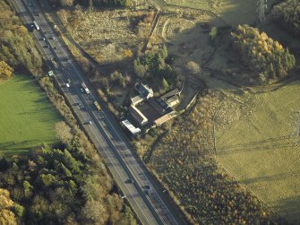 Oblique aerial view centred on the farmhouse, farmsteading and cottages, taken from the WNW.