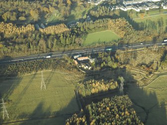 Oblique aerial view centred on the farmhouse, farmsteading and cottages, taken from the S.