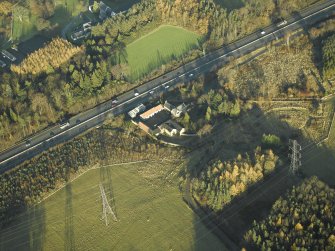 Oblique aerial view centred on the farmhouse, farmsteading and cottages, taken from the SW.