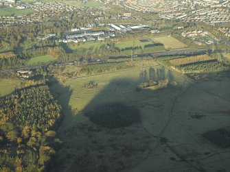 General oblique aerial view centred on the remains of the practice trenches with the farmhouse, farmsteading and cottages adjacent and the barracks in the distance, taken from the S.