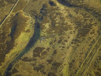 Oblique aerial view centred on the remains of the long cairn, taken from the WNW.