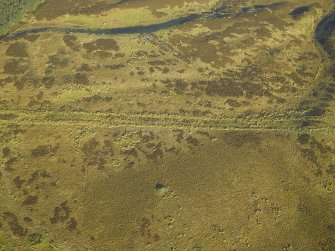 Oblique aerial view centred on the remains of the cairns and field-system, taken from the S.