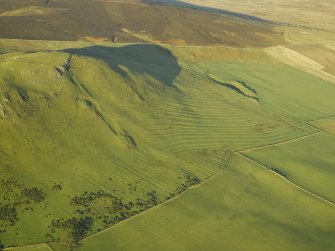 Oblique aerial view centred on the remains of the cultivation terraces, rig and sheepfold, taken from the S.