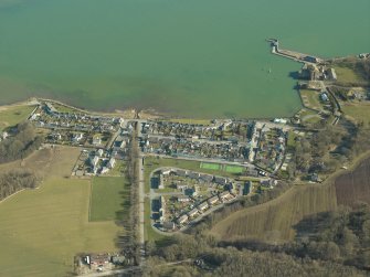 Oblique aerial view centred on the village with the harbour and mill adjacent, taken from the W.