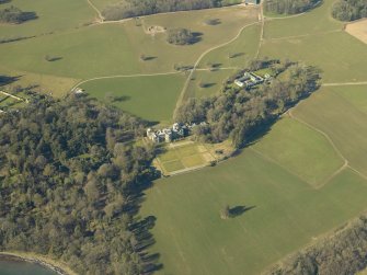 Oblique aerial view centred on the country house, garden and farmsteading, taken from the E.