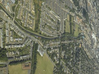 General oblique aerial view of the city centred on the course of the canal and the sports field, taken from the SW.