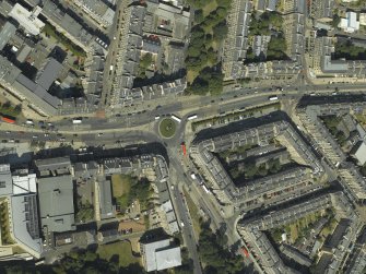 Oblique aerial view centred on the bank and tenements with the school adjacent, taken from the SW.