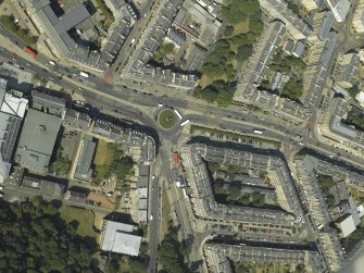 Oblique aerial view centred on the bank and tenements with the school adjacent, taken from the SW.