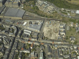 Oblique aerial view centred on the railway goods station and the construction of the car park with the offices adjacent, taken from the SE.