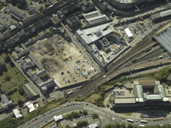 Oblique aerial view centred on the railway goods station and the construction of the car park with the offices adjacent, taken from the NE.