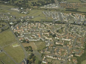 Oblique aerial view of the housing estate with the school adjacent, taken from the SE.