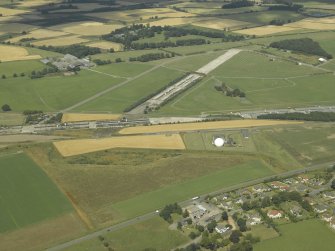 General oblique aerial view centred on the radio station and airfield with the aircraft hangars in the distance, taken from the SSE.