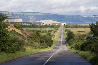 General view of yard from SSE, with the approach road stretching out in the foreground, and the Moray Firth and Black Isle in the background.