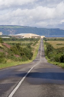 Distant general view of yard from SE, with the approach road stretching out in the foreground, and the Moray Firth and Black Isle in the background.