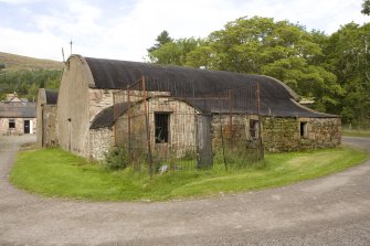 Curved roof building to SE of site, view from SW