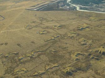 Oblique aerial view centred on the remains of the coal mines and bell pits, taken from the NE.