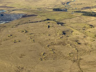 Oblique aerial view centred on the remains of the coal mines and bell pits, taken from the SE.