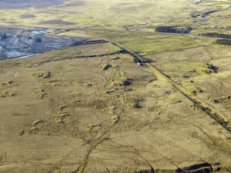 Oblique aerial view centred on the remains of the coal mines, bell pits and dismantled railway, taken from the ESE.