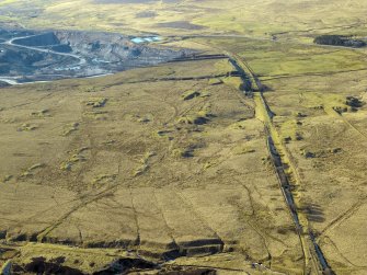 Oblique aerial view centred on the remains of the coal mines, bell pits and dismantled railway, taken from the E.