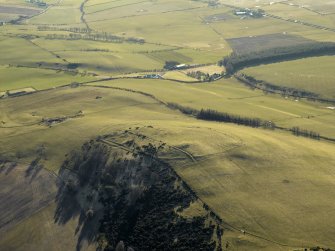 General oblique aerial view centred on the remains of the fort, settlement and cairn, taken from the NE.