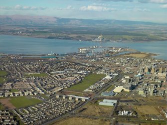 General oblique aerial view of the town, centred on the oil refinery, stadium and docks, taken from the S.