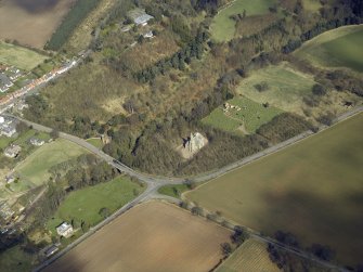 General oblique aerial view centred on the church, burial-ground, war memorial, gatelodge and remains of the church, taken from the SW.