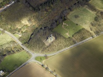 Oblique aerial view centred on the church, burial-ground, war memorial, gatelodge and remains of the church, taken from the S.