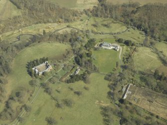 General oblique aerial view centred on the country house, stables, glasshouse and walled garden, taken from the SW.