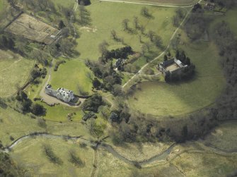 General oblique aerial view centred on the country house, stables, glasshouse and walled garden, taken from the NE.