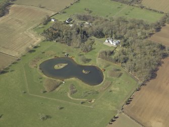 Oblique aerial view centred on the country house with the walled garden, cottages, barn and stable adjacent, taken from the SE.