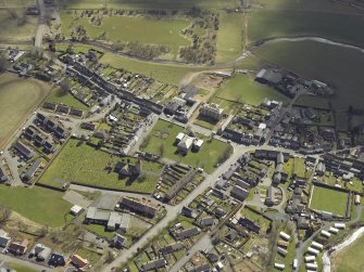 General oblique aerial view of the village centred on the county building, court house and town hall with the church, churchyard, burial-ground and hotel adjacent, taken from the NW.