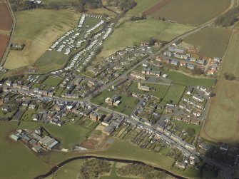 General oblique aerial view of the village centred on the county building, court house and town hall with the church, churchyard, burial-ground and hotel adjacent, taken from the SSE.