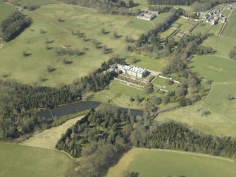 General oblique aerial view centred on the country house, garden, stable, footbridge and lake, taken from the SE.