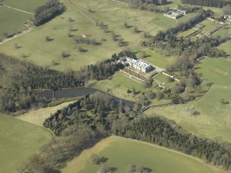 General oblique aerial view centred on the country house, garden, stable, footbridge and lake, taken from the E.