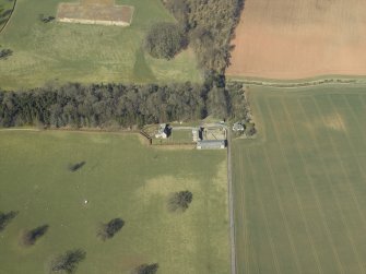 Oblique aerial view centred on the dovecot, kennel and cottage, taken from the SE.