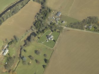 General oblique aerial view centred on the churches and burial-ground with the country house, school, farmhouse and farmsteading adjacent, taken from the SW.